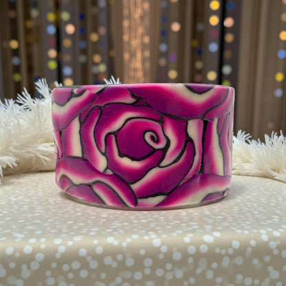 These Pretty Things Cherry Rose Cuff on a neutral colour base with a cream feather boa in the background