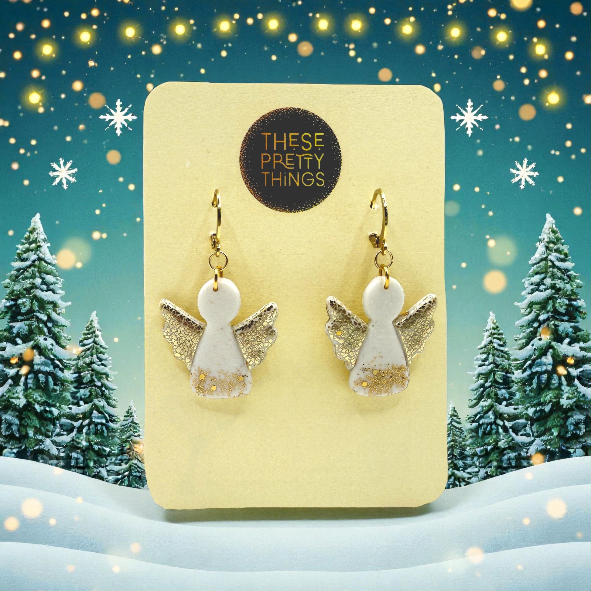 Christmas Angel earrings on a These Pretty Things presentation card with a snowy festuve landscape background.