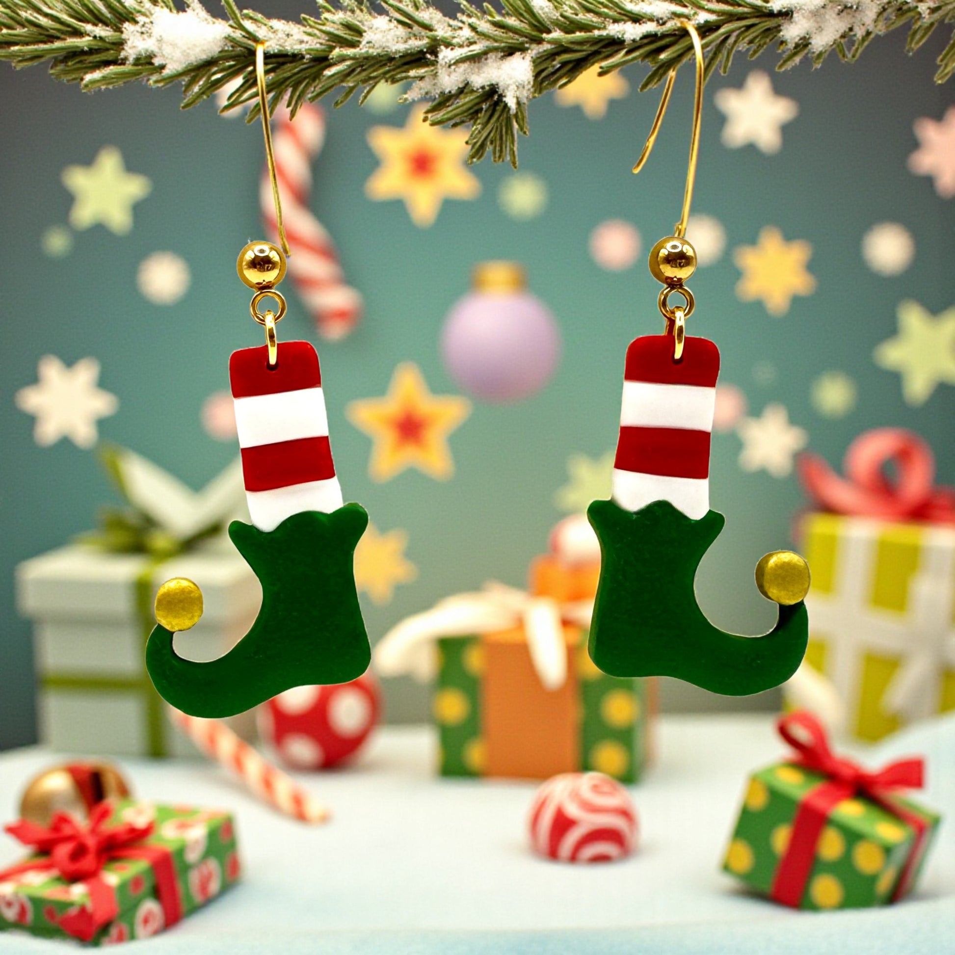 Christmas Elf Boots & Socks earrings from These Pretty Things on a festive background including stars and Christmas presents.