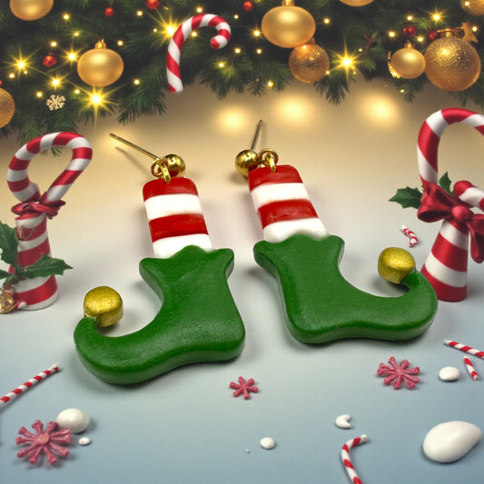 Christmas Elf Boots & Socks earrings from These Pretty Things on a festive background including candy canes and gold baubles.