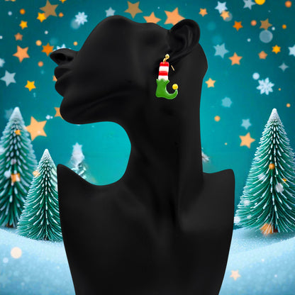 Elf Boots & Socks earrings on a black mannequin against a festive background with Christmas trees and stars.