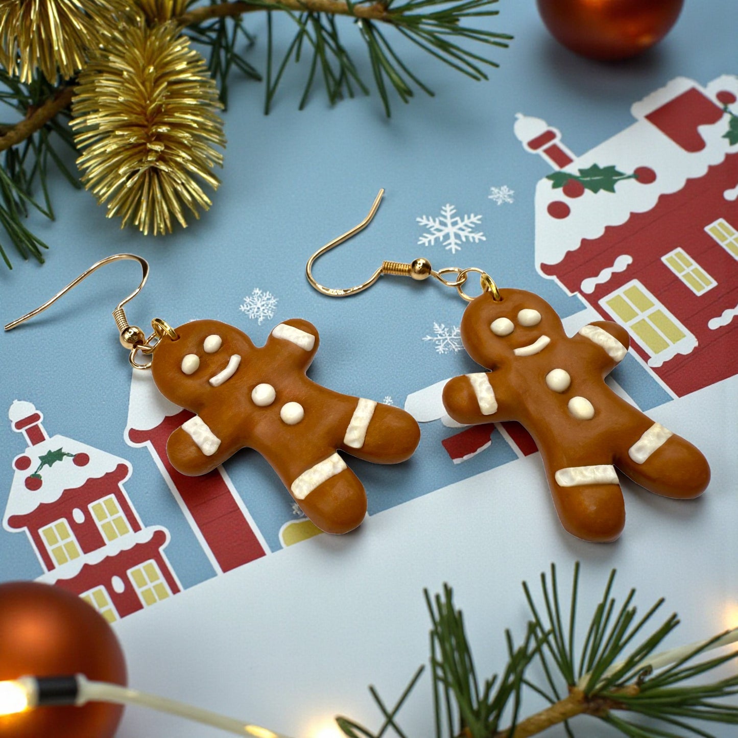 Gingerbread men earrings on a festive background with Christmas decorations.