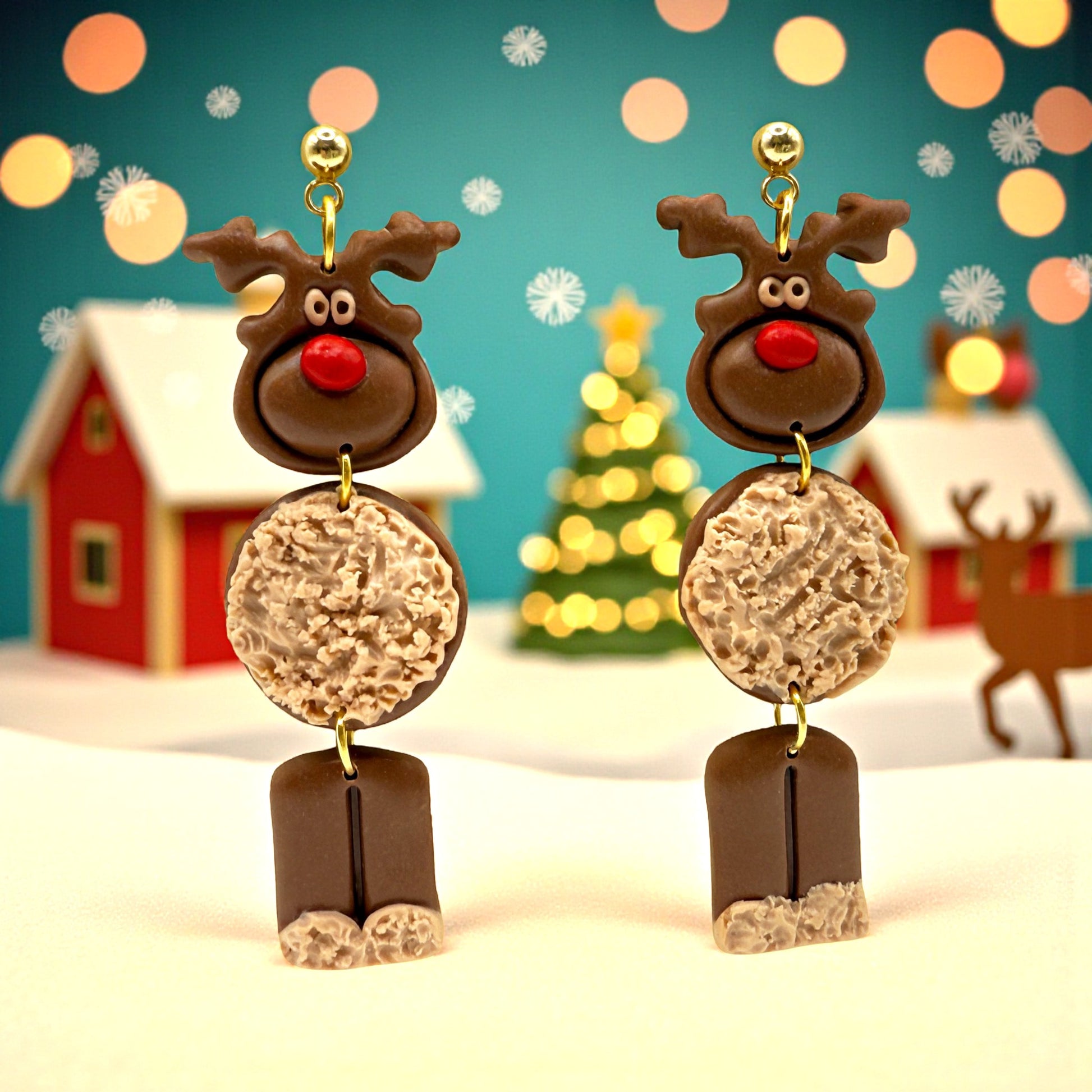 Reindeer earrings with a festive background featuring Christmas trees and houses.