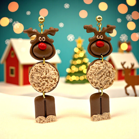 Reindeer earrings with a festive background featuring Christmas trees and houses.