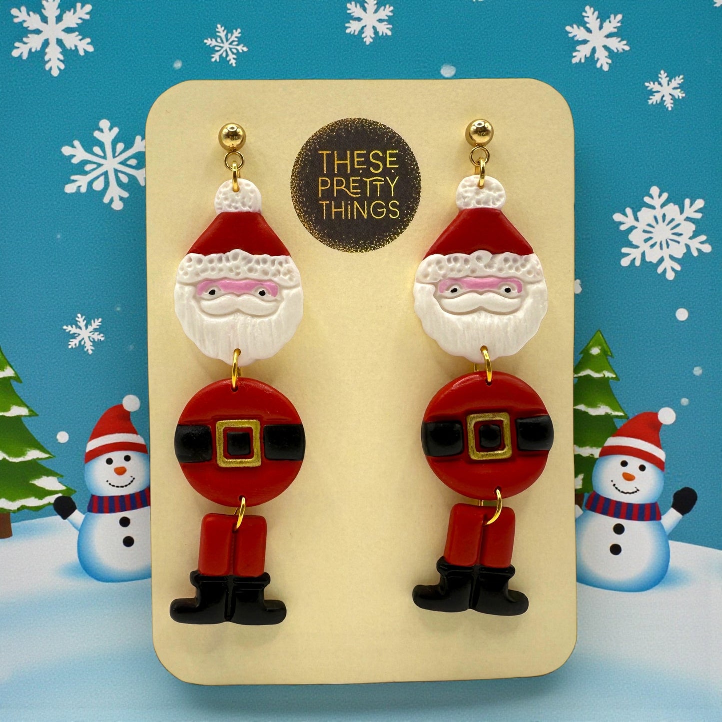 Santa Claus earrings on a 'These Pretty Things' card with a festive background