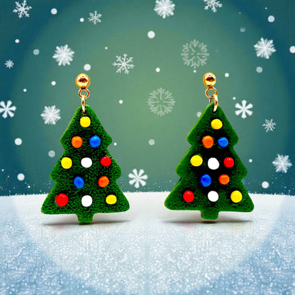Christmas tree earrings from These Pretty Things with colorful lights on a snowy background including snowflakes.
