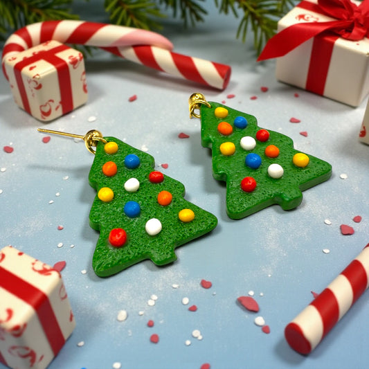 Christmas Tree earrings from These Pretty Things with a festive themed background including candy canes and presents.