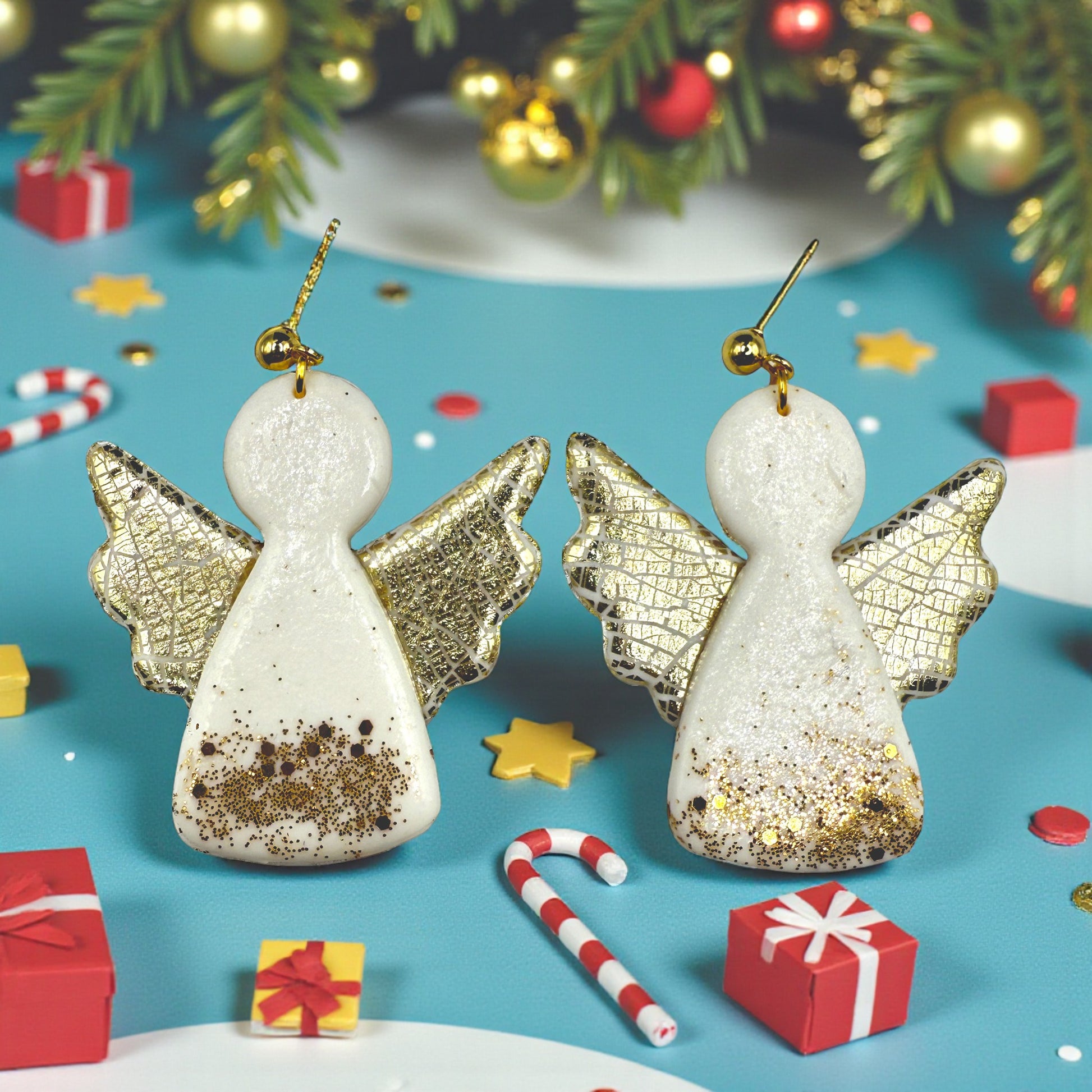 Christmas Angel earrings with gold glitter on a festive background with presents and candy canes.