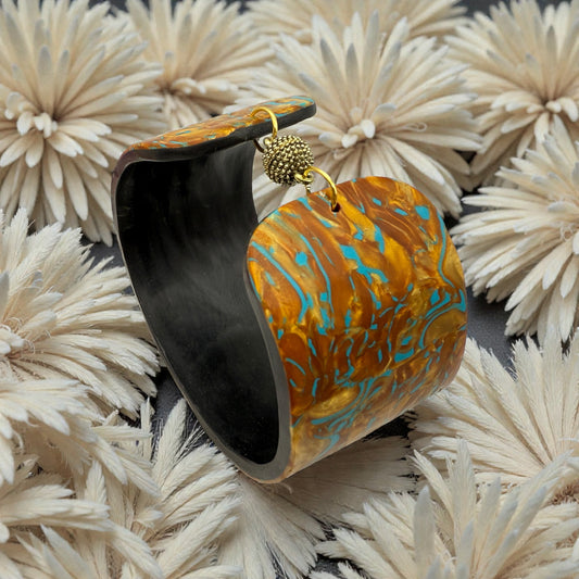 These Pretty Things Fire & Ice Cuff nestled within a cream feather boa.