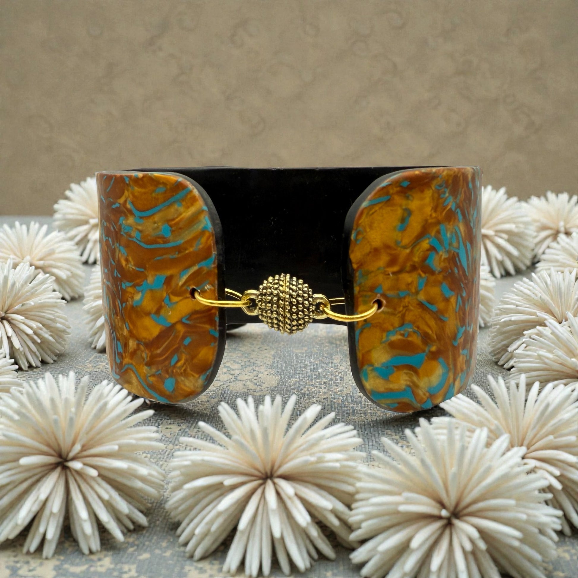 These Pretty Things Fire & Ice Cuff nestled within a cream feather boa.