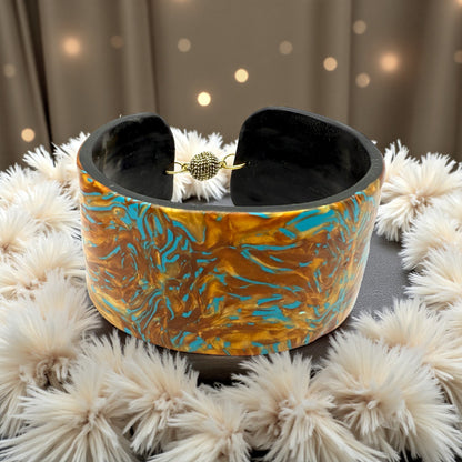 These Pretty Things Fire & Ice Cuff nestled within a cream feather boa.