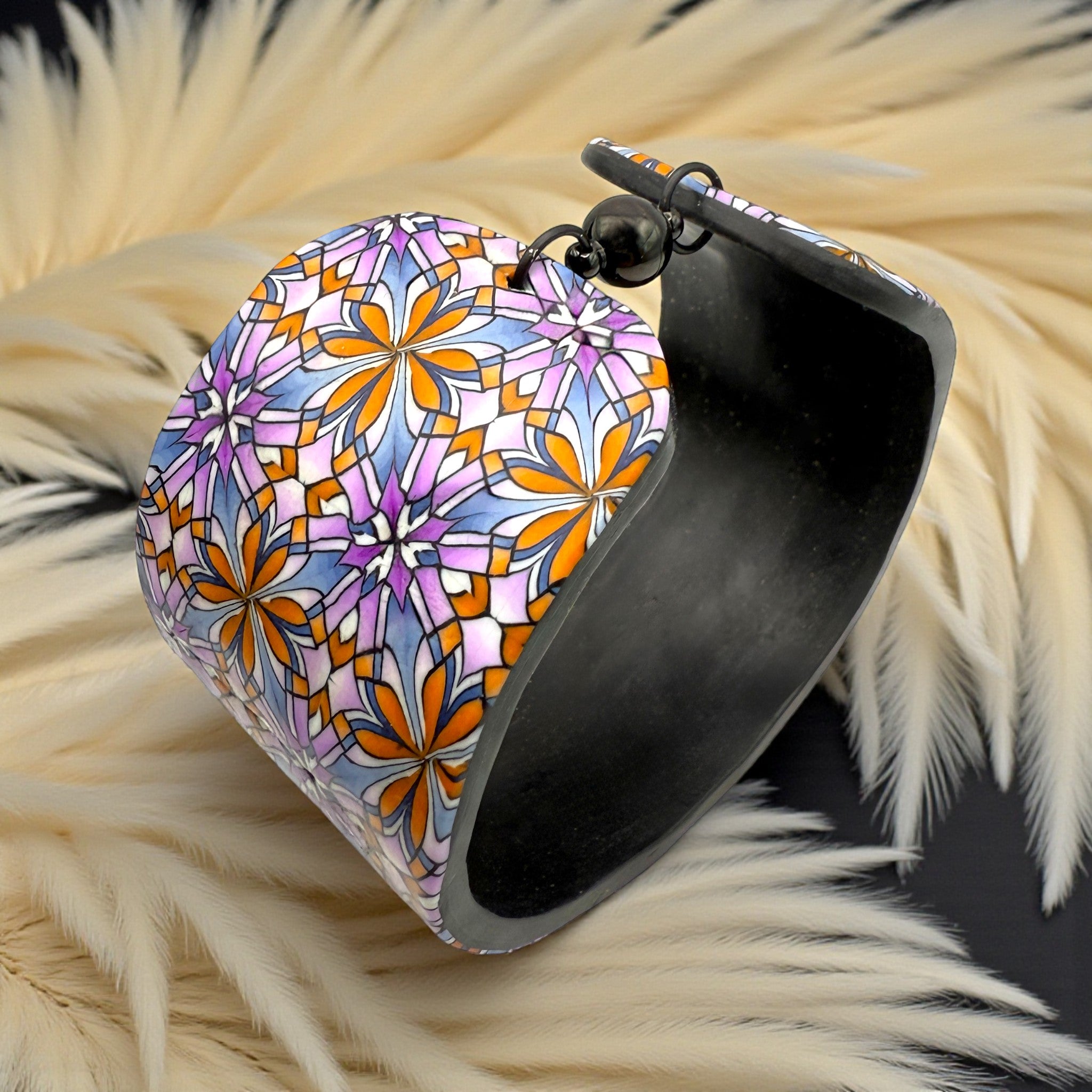 These Pretty Things Floral Geometric Cuff with a 1920's themed background including a beige feather boa.