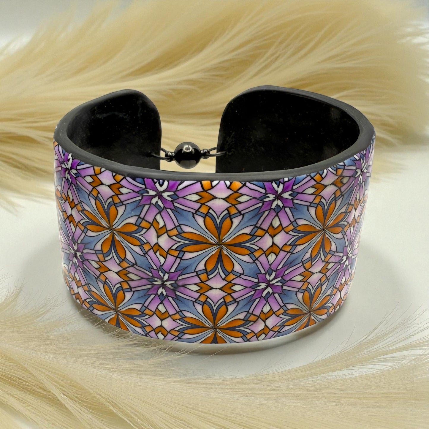 These Pretty Things Floral Geometric Cuff with a 1920's themed background including a beige feather boa.