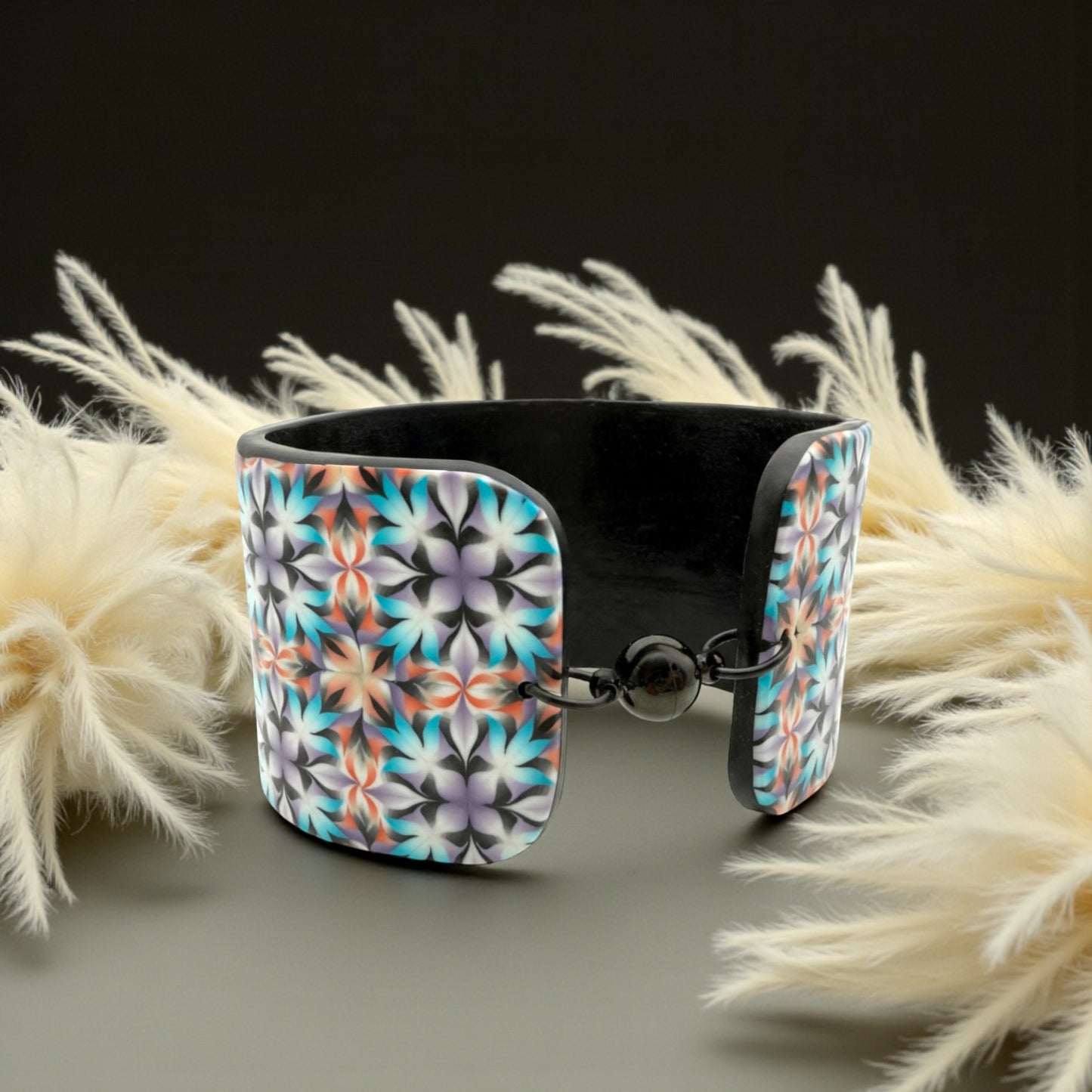 These Pretty Things Kaleidoscope Multicoloured Cuff with a 1920's inspired background using a cream feather boa.