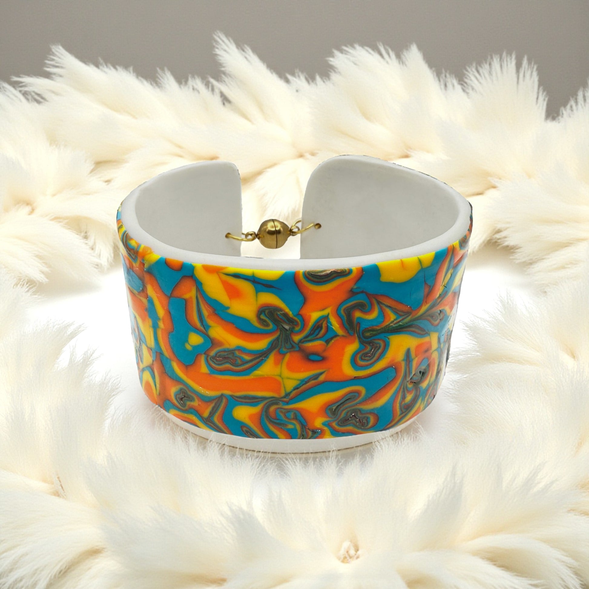 These Pretty Things Hawaiian Dream Cuff sitting within a white feather boa.