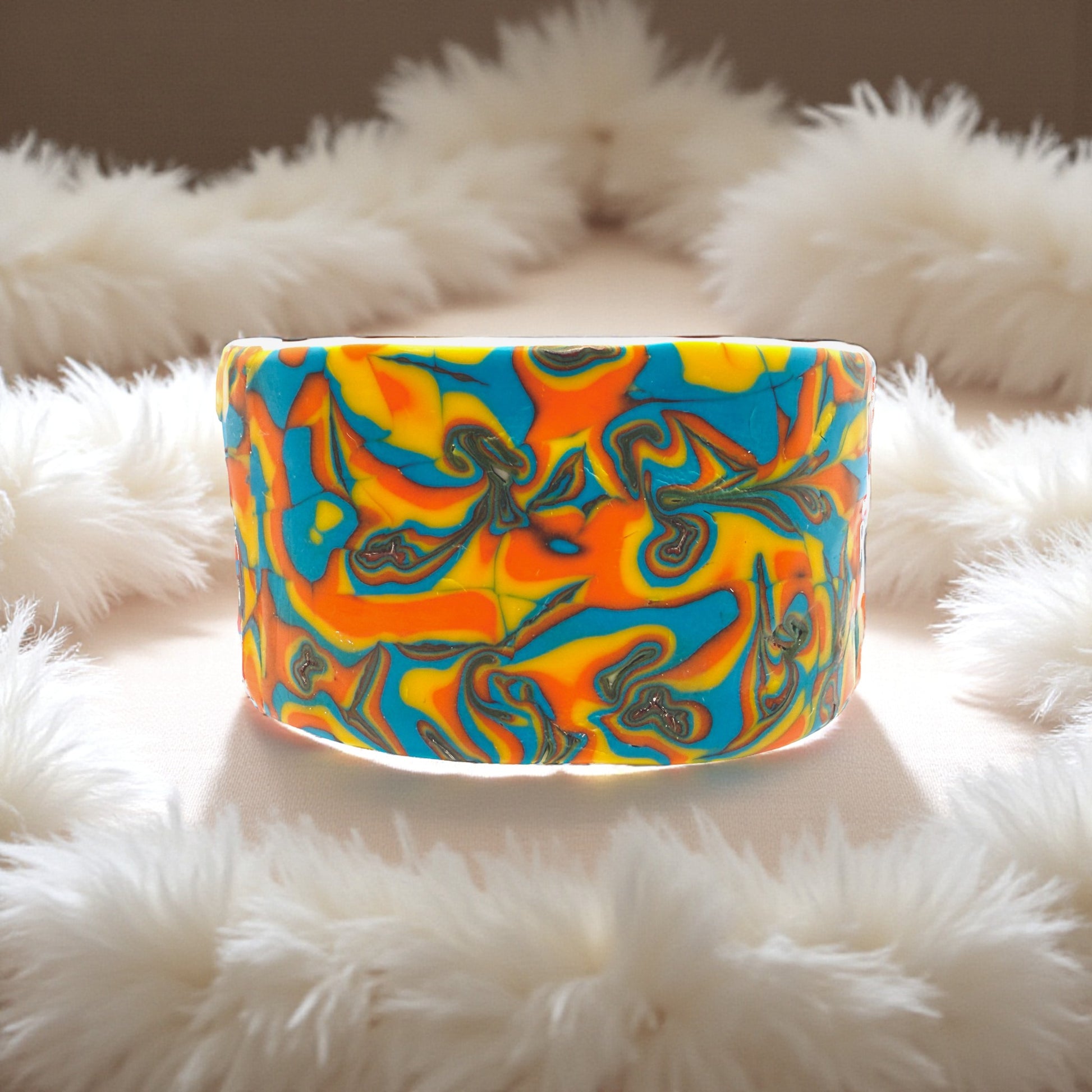 These Pretty Things Hawaiian Dream Cuff sitting within a white feather boa.