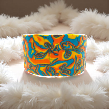 These Pretty Things Hawaiian Dream Cuff sitting within a white feather boa.