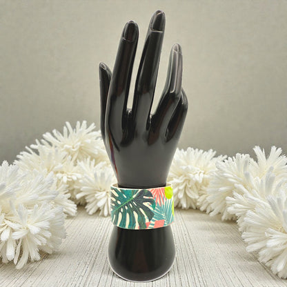 These Pretty Things Rainbow Forest Cuff on a  black hand mannequin with a creamy white feather boa in the background