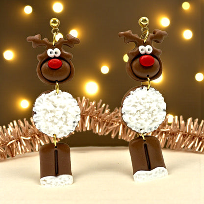 Dark brown Reindeer earrings with a white fur-like tummy set in a festive background with tinsel and fairy lights