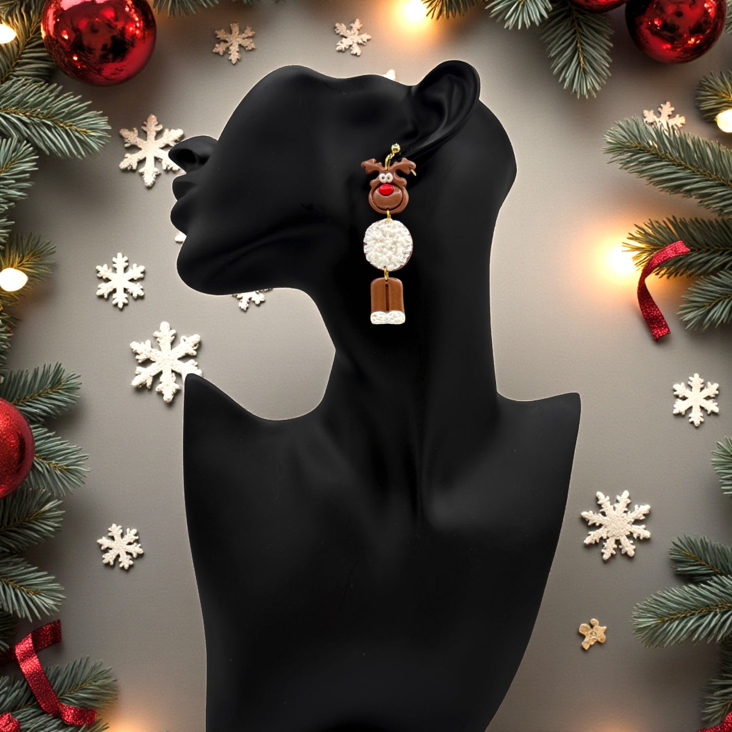 Black mannequin head with Christmas Reindeer earrings against a festive background with lights and decorations.